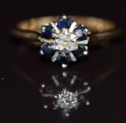 A 9ct gold ring set with a diamond surrounded by sapphires, 2.5g, size M