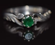 An 18ct white gold ring set with an emerald with ornate shoulders, 2.5g, size M/N