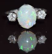 A platinum ring set with an oval opal cabochon and two diamonds, 3g, size P