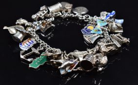 A silver charm bracelet with over 30 charms including enamel butterfly, enamel charms, fish,