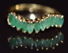 An 18ct gold ring set with marquise cut emeralds, size O, 2.8g