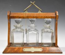 Oak three bottle tantalus by Daniel and Arter limited, height 34cm