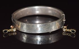 Hallmarked silver bangle with engraved floral decoration and a pair of 9ct gold earrings each set