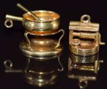 An 18ct gold charm in the form of a Chinese wok (2.6g) and a 9ct gold charm in the form of a wishing