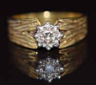 An 18ct gold ring set with a diamond in a platinum setting, with textured shoulders, 5.8g, size N