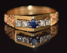 A 1970's 18ct gold ring set with a sapphire and diamonds, with textured shoulders, Birmingham