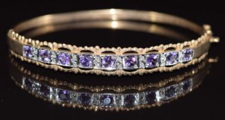 A 9ct gold bangle set with amethysts and diamonds, 11.2g