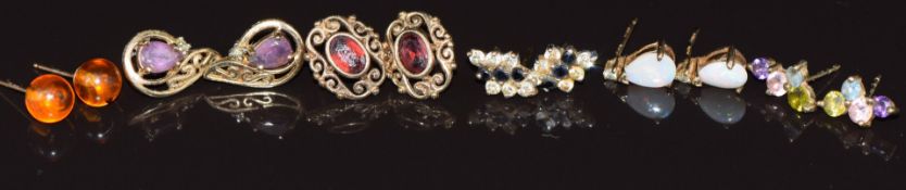 Six pairs of 9ct gold earrings set with garnets, amethyst, opals, sapphires and cubic zirconia, etc,