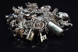 A silver charm bracelet with over 45 silver charms including hedgehog, church, bible, boat, key,