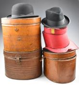 Three tin hat boxes including top hats, one with burgundy felt interior (exterior silk missing)