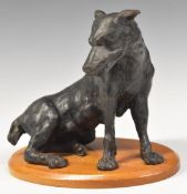 Cast metal figure of a large seated dog on oval mahogany plinth, height 15cm