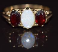 A 9ct gold ring set with an opal and two garnets, 2.6g, size M