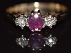 A 9ct gold ring set with an oval cut ruby and diamonds, 2.2g, size T