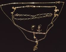 A 9ct gold chain, two 9ct gold treble clefs, one set with an emerald, two 9ct gold charms and a