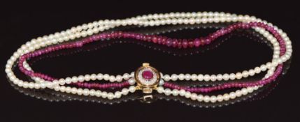 A three strand pearl and ruby necklace with 18ct gold clasp set with a ruby cabochon and diamonds