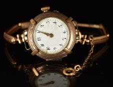 Unnamed yellow metal ladies wristwatch with gold hands , black Arabic numerals, white dial and