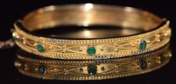 Victorian Etruscan Revival yellow metal bangle set with emeralds, 11.2g