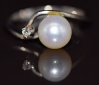 An 18ct white gold ring set with a pearl and diamond, 3.9g, size L
