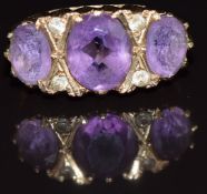 A 9ct gold ring set with three oval amethysts and spinel, 3.8g, size L