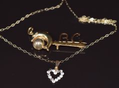 An 18ct gold brooch (1.3g), 9ct gold pendant in the form of a dolphin and a 9ct gold chain (2g)