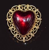 Late Victorian 9ct gold brooch set with a foiled heart cut garnet cabochon with a filigree border,