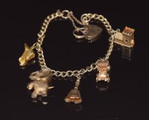 A 9ct gold charm bracelet with five 9ct gold charms including elephant, car, church, etc, 20.9g