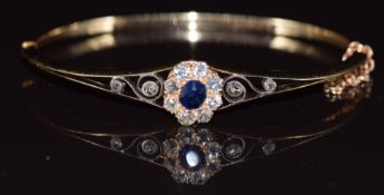 Victorian 9ct gold bangle set with an oval cut sapphire surrounded by old cut diamonds, in antique