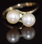 An 18k gold ring set with two cultured pearls in a twist setting, 3.2g, size S