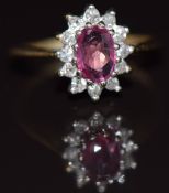 A 9ct gold ring set with an oval cut pink sapphire surrounded by diamonds, 1.7g, size E