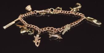 A 9ct rose gold charm bracelet with eight 9ct gold charms including dachshund, cricket bat, pear,