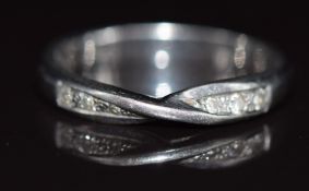 A platinum wedding band / ring with twisted design to fit around an engagement ring, set with six