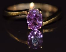 A 9ct gold ring set with an oval cut pink sapphire, 2.8g, size N
