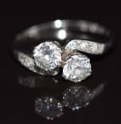 A c1920 18ct white gold 'toi et moi' ring set with two diamonds each approximately 0.4ct, in a twist