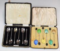 Two cased sets of hallmarked silver spoons, comprising a coloured guilloché enamel backed set,