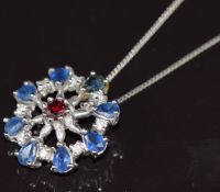 A 9k white gold pendant set with a ruby, sapphires and diamonds with two 9k white gold chains, 4g