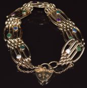 A 9ct gold gate bracelet set with emerald, tourmaline, amethyst, sapphires, rubies, etc 21cm