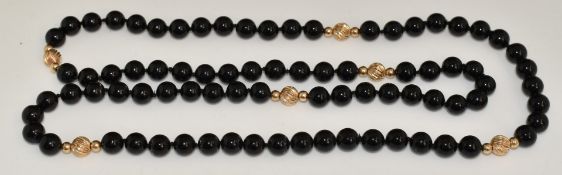 A necklace of onyx beads interspersed with 9ct gold beads