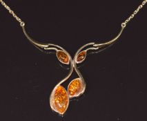 A 9ct gold necklace set with pressed amber cabochons, 4.3g