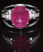 An 18ct white gold ring set with an oval cut ruby and white topaz, 8.3g, size N