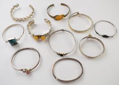 Ten silver bangles including turquoise, amber, etc