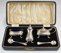 Cased George V hallmarked silver three piece cruet set with blue glass liner to the salt, together