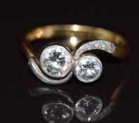 An 18ct gold 'toi et moi' ring set with two diamonds of approximately 0.65ct and 0.35ct in a