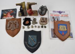 A collection of Terry Pratchett Discworld ephemera including Clarecraft figurines, coats of arms,