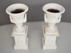 Pair of cast iron campagna urns on separate matching plinths, height 60cm