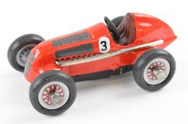 Schuco Studio 1050 clockwork tinplate racing car with red body, brown interior and silver hubs.