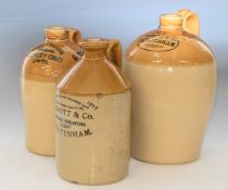 Three Cheltenham interest stoneware flagons comprising Knott & Co, Dobell & Co and Cheltenham