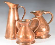Three copper jugs comprising 1 quart and half gallon measuring jugs and a J.S & S tapering