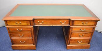 Mahogany leather inset breakfront twin pedestal desk fitted five drawers and a cupboard, the front