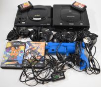 Two retro games consoles comprising Sega Mega Drive and Sega Saturn together with controllers, light