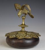 Brass or similar model of a bird with outswept wings, currently mounted on a brass and wooden base
